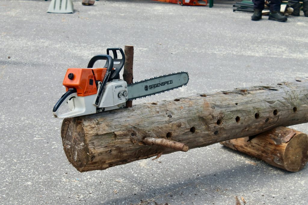 souffleuse à neige orange et blanche sur une bûche de bois marron